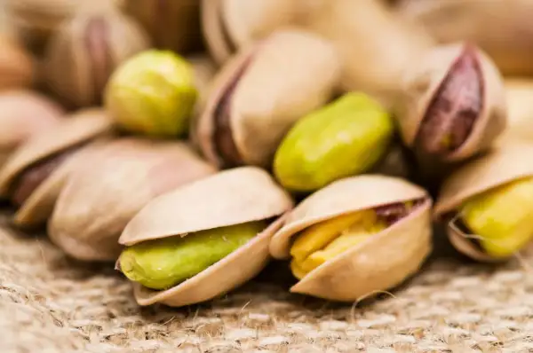 Pistacchi tostati su tela di juta. Attenzione, i pistacchi fanno ingrassare se consumati in grandi quantità!