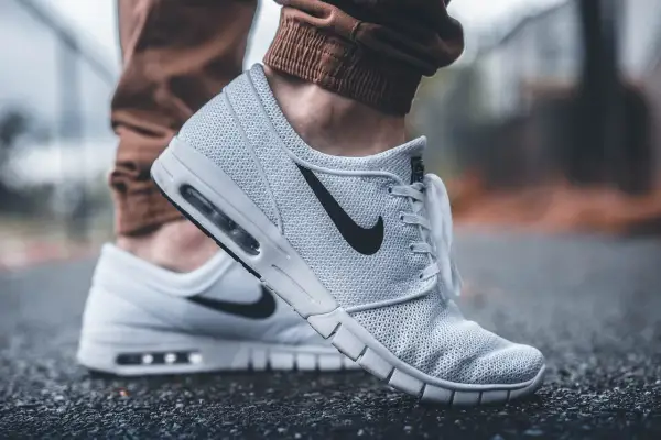 Białe buty sportowe Nike z czarnym logo. Dobre wsparcie dla stóp, idealne jako buty przy zapalenie rozcięgna podeszwowego.