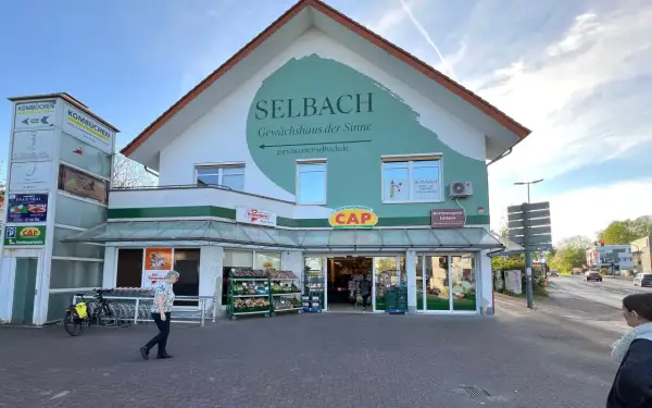 Ein Supermarkt und Gartencenter "Selbach" im Bergischen Land heute. Ein CAP-Markt und eine Metzgerei sind ebenfalls Teil des Gebäudes.