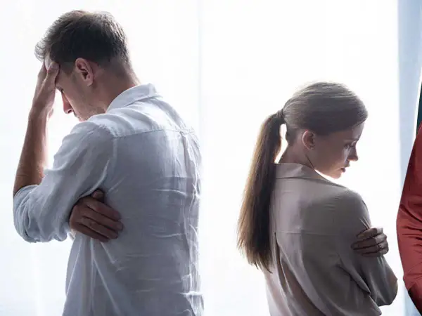 Ett par vänder ryggen åt varandra, en man med handen mot pannan, en kvinna med armarna i kors. Kanske en svår tid för anna bennich partner.