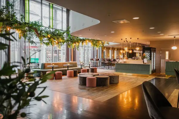 Mysig lounge med grönska och belysning, perfekt för en hotel Dorsia lunch.