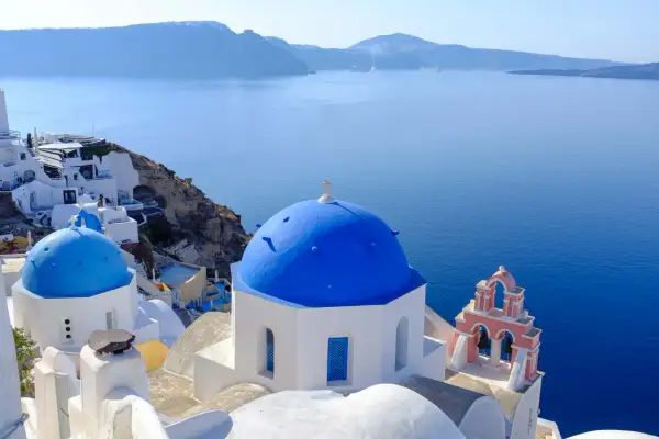 Błękitne kopuły kościołów na Santorini, idealne na wakacje. Marzysz o Santorini loty bezpośrednie?