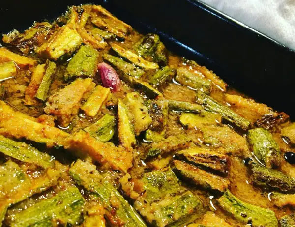 Zucchine in carpione, un piatto saporito e colorato, con pezzi di zucchine dorati e immersi in una marinatura aromatica.