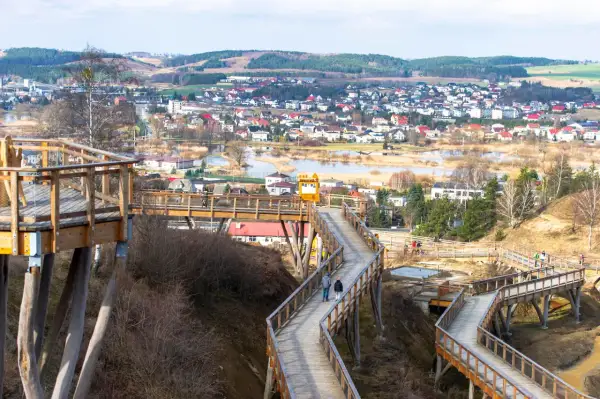 Drewniana wieża widokowa wije się wśród drzew, oferując panoramę miasteczka i jeziora.