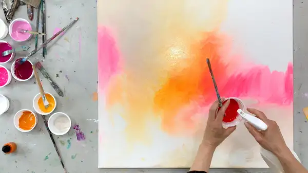Bunte Farben auf einer Leinwand, bereit zum leinwand bemalen mit kindern. Pinsel und Becher mit Farbe liegen bereit.