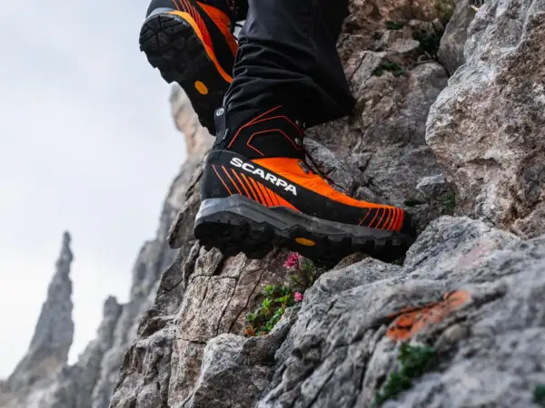Des chaussures de randonnée Scarpa orange et noires, parfaites pour choisir son chemin sur les rochers escarpés.