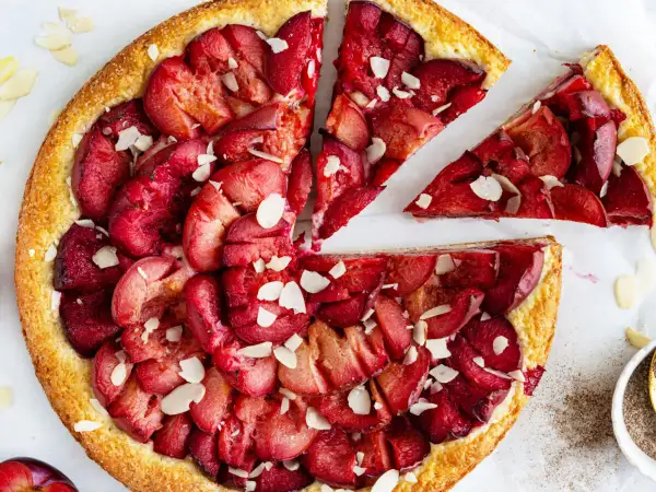 Ein schneller Pflaumenkuchen mit Quark, belegt mit saftigen Pflaumen und Mandelsplittern. Perfekt für den Kaffeetisch!