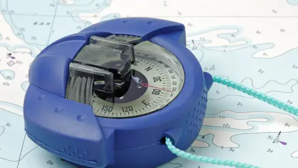 Una bussola blu su una mappa nautica, pronta per guidare l'avventura.