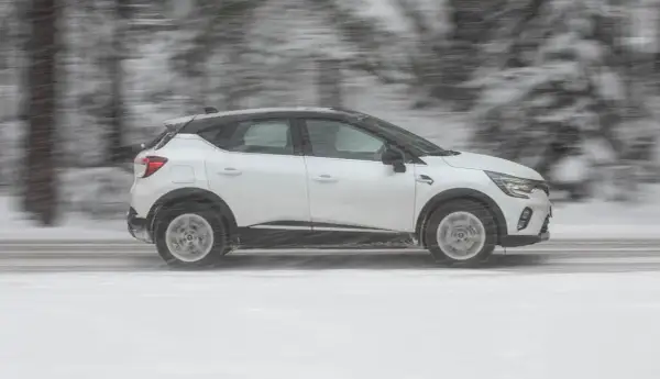 Vit Renault Captur kör i snöstorm. Kanske ett problem med väggreppet?