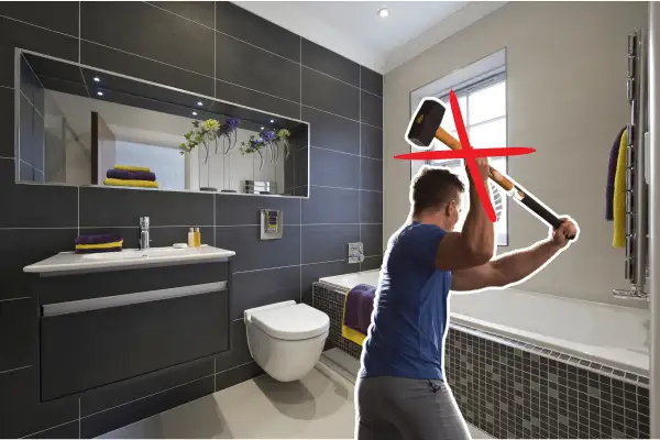 Un homme s'apprête à casser le carrelage mural de la salle de bain avec une masse. Une croix rouge indique que ce n'est pas la bonne méthode.