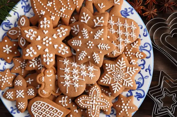 Talerz pełen pierniczków staropolskich (długodojrzewających) ozdobionych białym lukrem. Wśród nich gwiazdki, płatki śniegu i ludziki.