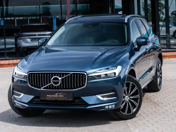 Elegancki, ciemnoniebieski SUV Volvo z chromowanym grillem. Idealny wybór dla szukających auta do 60 tys.