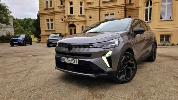 Szary Renault Symbioz przed zabytkowym budynkiem. Wiele osób szuka **Renault Symbioz opinie**, a ten model wygląda obiecująco.