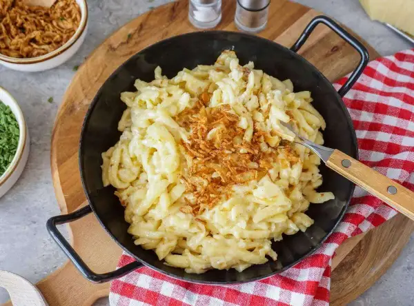 Herzhafte Käsespätzle mit knusprigen Röstzwiebeln, perfekt, um Sahne zu verwerten.