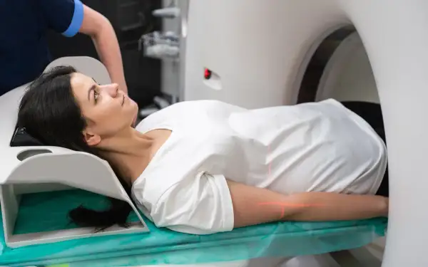 Frau liegt auf Liege für PET-CT-Untersuchung. Rote Laserlinien markieren Position.