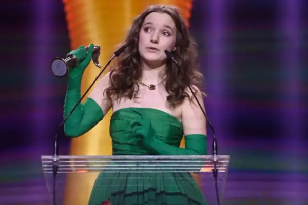 Sanah z nagrodą, w zielonej sukni i rękawiczkach, przemawia do mikrofonu. Zastanawiasz się, ile kosztuje bilet na koncert sanah?