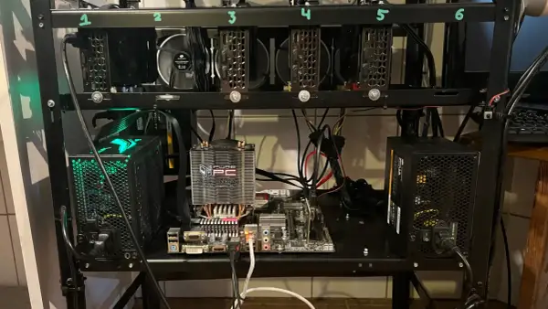 Rig do kopania kryptowaluty z sześcioma kartami graficznymi, płytą główną i zasilaczami.