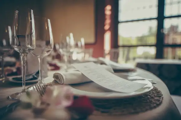 Mesa elegante con copas, cubiertos y menú. ¿Cuántas estrellas Michelin se pueden tener en una cena así?