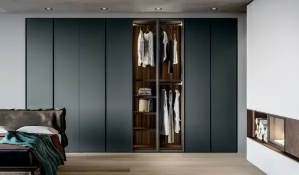 Armadio a muro con ante scorrevoli, che mostra l'interno con abiti appesi e ripiani. Le dimensioni armadio camera da letto sono perfette per un look moderno.