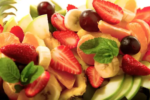 Bunter Obstsalat mit Erdbeeren, Bananen, Mandarinen, Äpfeln und Trauben. Ein erfrischendes, gekochtes Obst-Erlebnis.