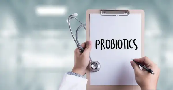 Lekarz trzyma stetoskop i notatnik z napisem "PROBIOTICS". Zastanawia się, do kiedy podawać probiotyk niemowlakowi.