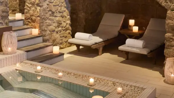 Relájate en este spa urbano con piscina, tumbonas y velas. Un oasis de paz y tranquilidad.