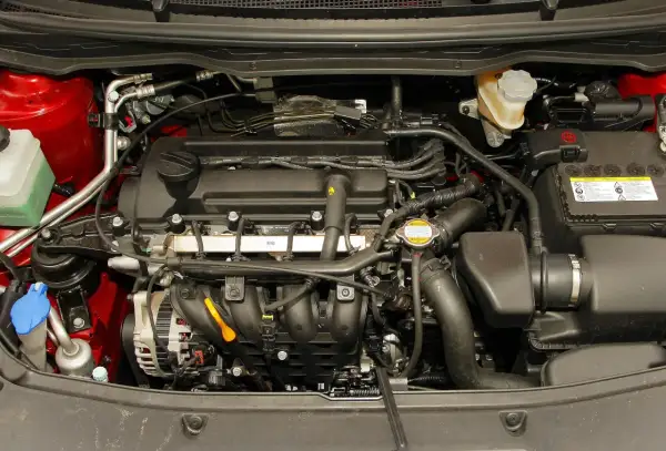 Silnik Hyundai i20 1.2 benzyna. Widoczny alternator, akumulator, płyny i przewody.