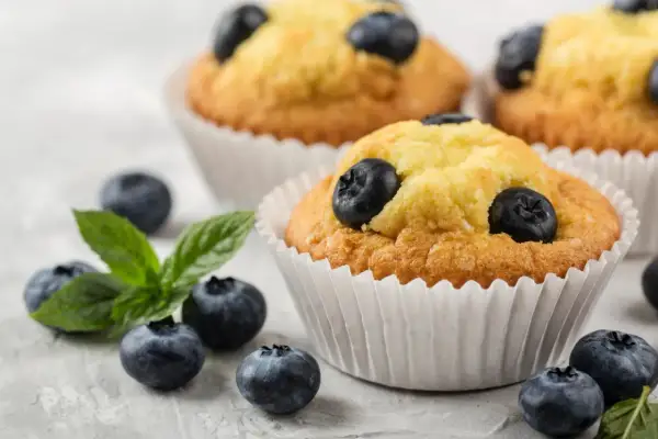 Pyszne muffinki z borówkami, świeże i pachnące, z dodatkiem listków mięty. Idealne na deser.