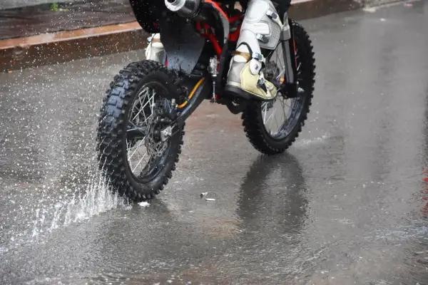 Niezwykła jazda motocyklem w deszczu. Błoto i woda rozpryskują się spod kół, tworząc widowiskowy pokaz.