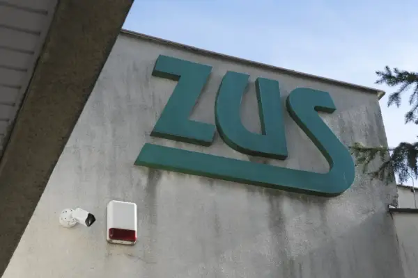 Znak ZUS. Tu złożysz wniosek o rentę rodzinną. Obok kamery i sygnalizator alarmowy.
