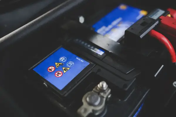 Bilbatteri med varningssymboler. Ett dåligt bilbatteri symptom kan vara att bilen inte startar.
