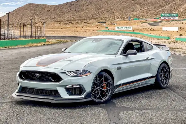 Jasnoszary Ford Mustang Mach 1 z pomarańczowymi akcentami na torze wyścigowym Willow Springs.