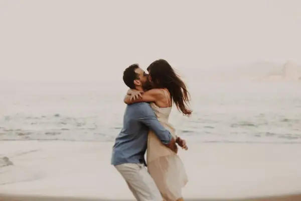 Pareja besándose en la playa, un abrazo que expresa los lenguajes del amor.