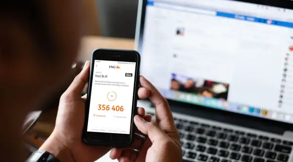 Oszustwo na BLIK: kod 356 406 na ekranie telefonu, obok laptop z otwartym Facebookiem.