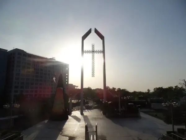 Ein monumentales Kreuz ragt im Gegenlicht empor, ein Symbol der Hoffnung, das mit dem Erbe von David Yonggi Cho verbunden ist.