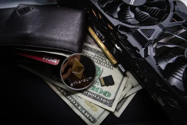 Portfel, karta Visa, moneta Ethereum, banknoty 100 USD i karta graficzna. To wszystko może być związane z tym, co to jest airdrop kryptowaluty.