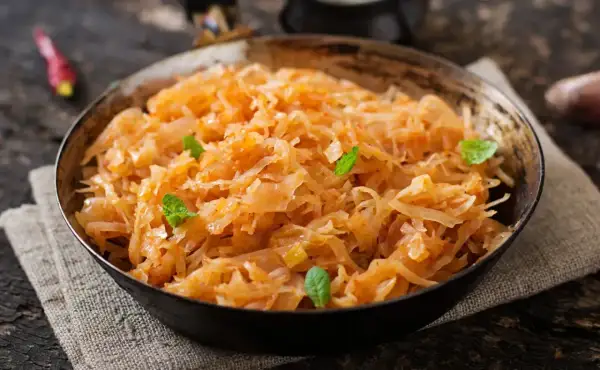 Pyszny bigos wegetariański w misce, ozdobiony listkami mięty. Aromatyczne danie z kapusty i warzyw.