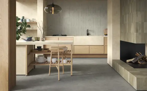 Cucina moderna con finiture in pittura colore sabbia del deserto, isola centrale in legno e camino.