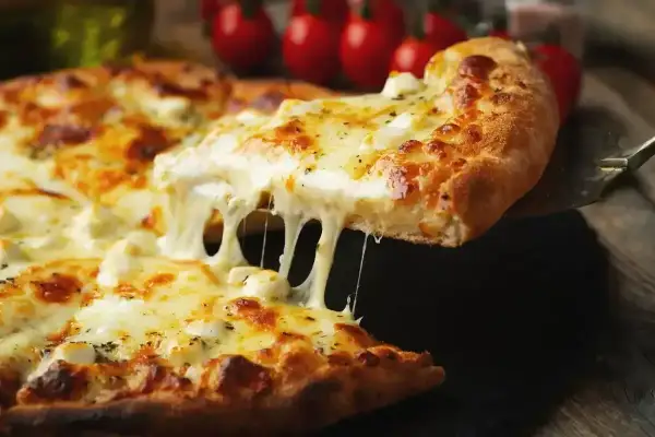 Rozciągający się, gorący ser na pizzy. Idealny przykład, jaki ser do pizzy wybrać, by uzyskać taki efekt.