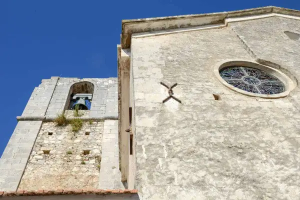 Campanile e rosone di Sant'Elia a Peschici, con il cielo azzurro sullo sfondo.