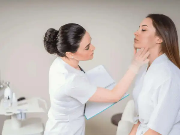 Dermatolog bada skórę pacjentki, by ocenić jej stan i dobrać odpowiednie zabiegi.