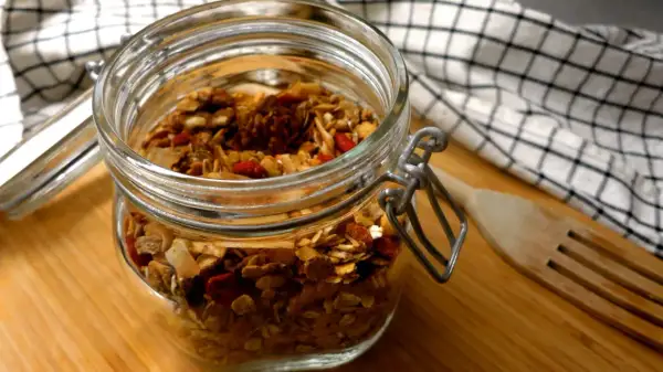 En burk med hemmagjord granola, perfekt som ett bra mellanmål på jobbet. Innehåller nötter, frön och torkad frukt.