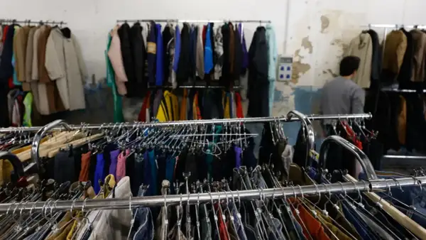 Perchate tesoros en el mercadillo vintage Zaragoza. Ropa de segunda mano colgada en percheros, esperando ser descubierta.