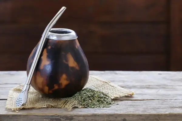 Naczynie z tykwy palo santo, gotowe do pierwszego użycia. Obok yerba mate i metalowa bombilla.