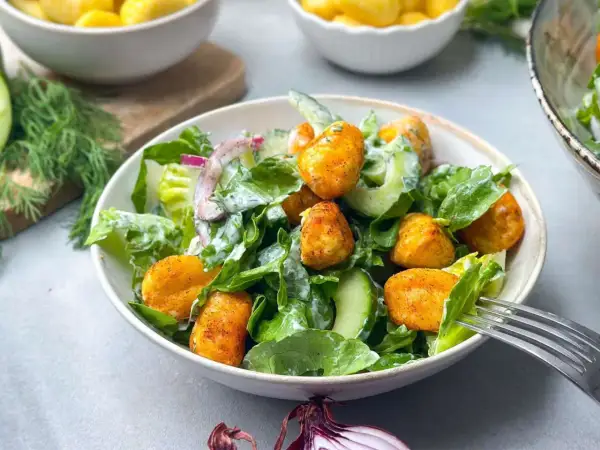 Knuspriger Gnocchi Salat mit Gurken, Zwiebeln und cremigem Dressing. Ein leckeres Gericht für jede Gelegenheit.
