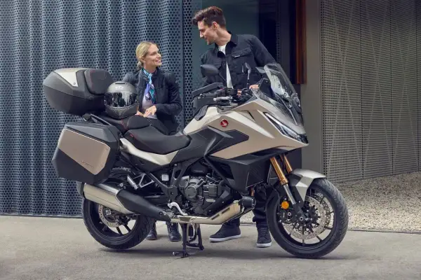 Para zwiedzająca motocykle z automatyczną skrzynią biegów. Nowoczesny turystyczny motocykl Honda z kuframi.