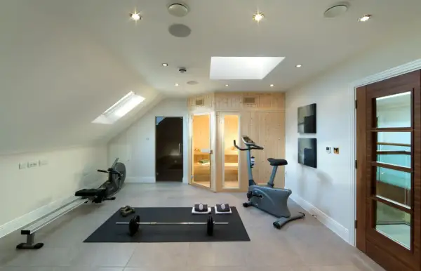 Accogliente palestra in mansarda con vogatore, cyclette, pesi e sauna. Ideale per allenarsi e rilassarsi.