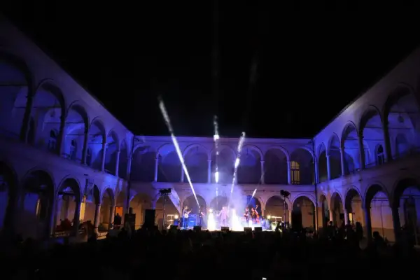 Concerto live sotto gli archi illuminati, un'atmosfera magica per la festa della musica a Brescia.