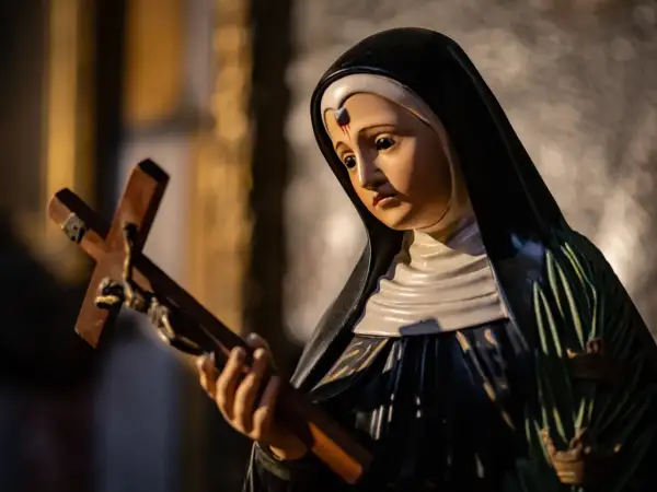 Figurka świętej Rity od spraw beznadziejnych trzyma krzyż.