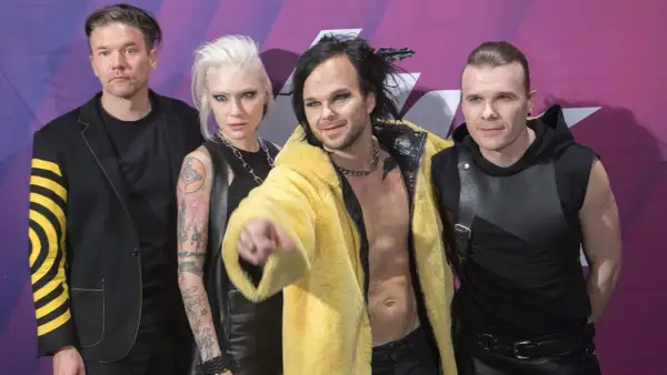 Zespół The Rasmus na koncercie, w tym wokalista Lauri Ylönen w żółtym futrze.